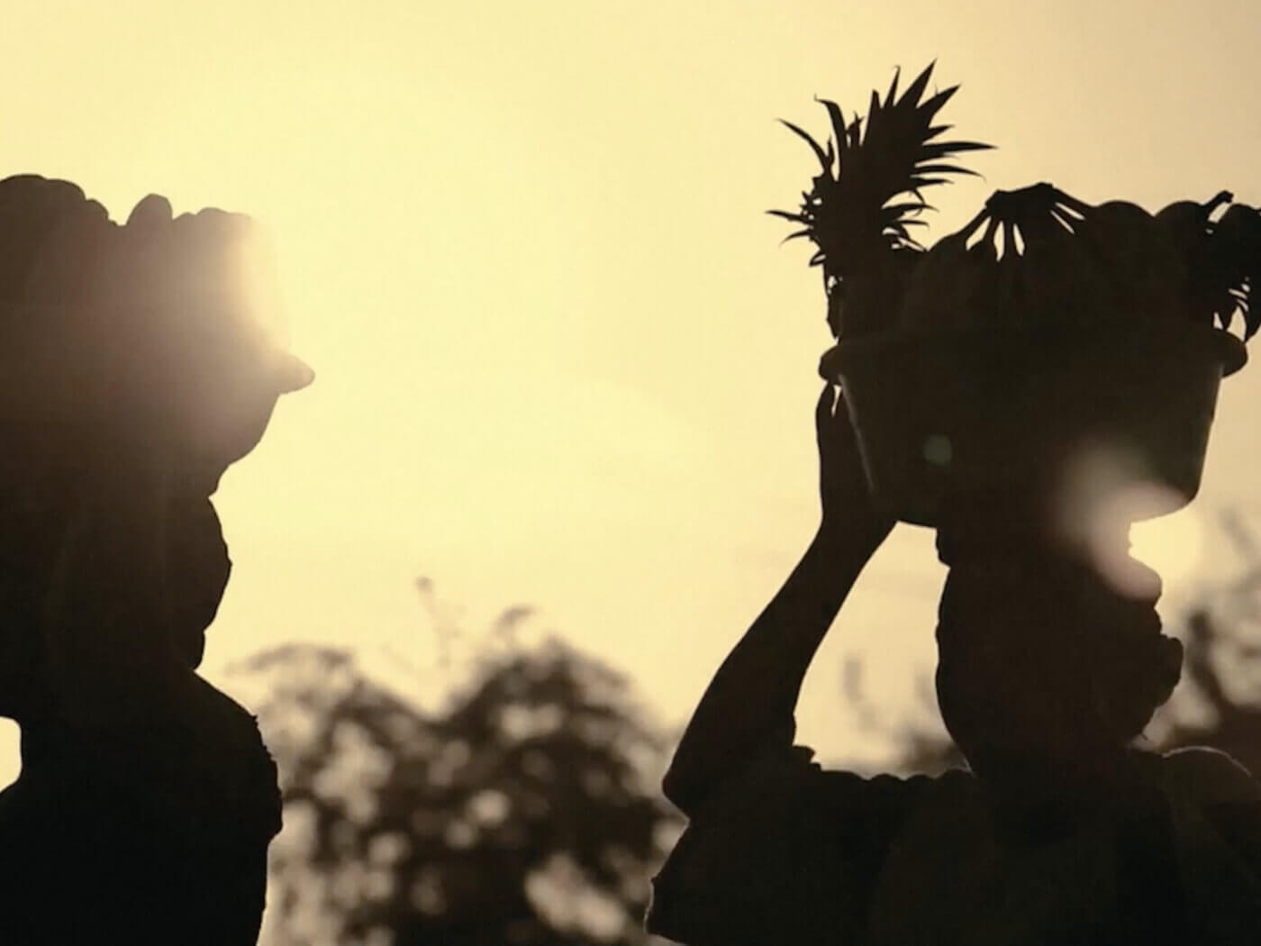Silhouette of women with baskets on their heads